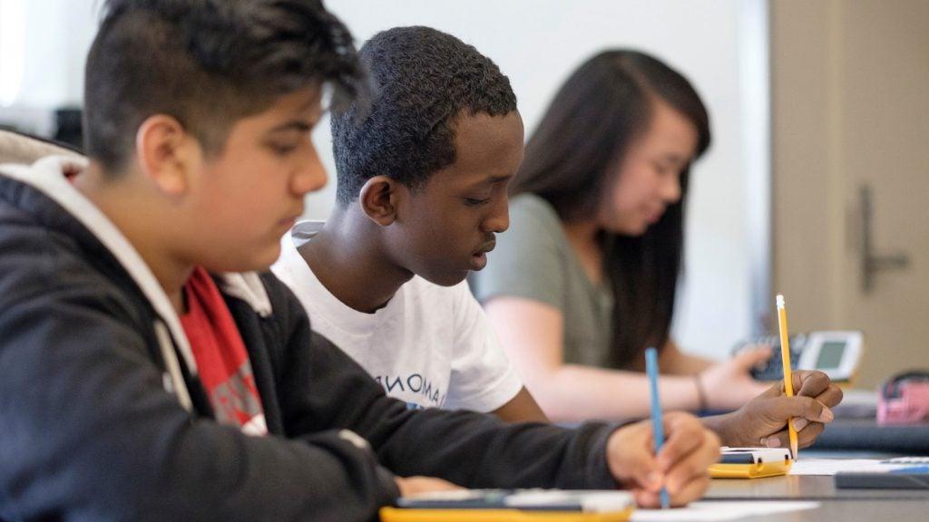 students writing at a desk